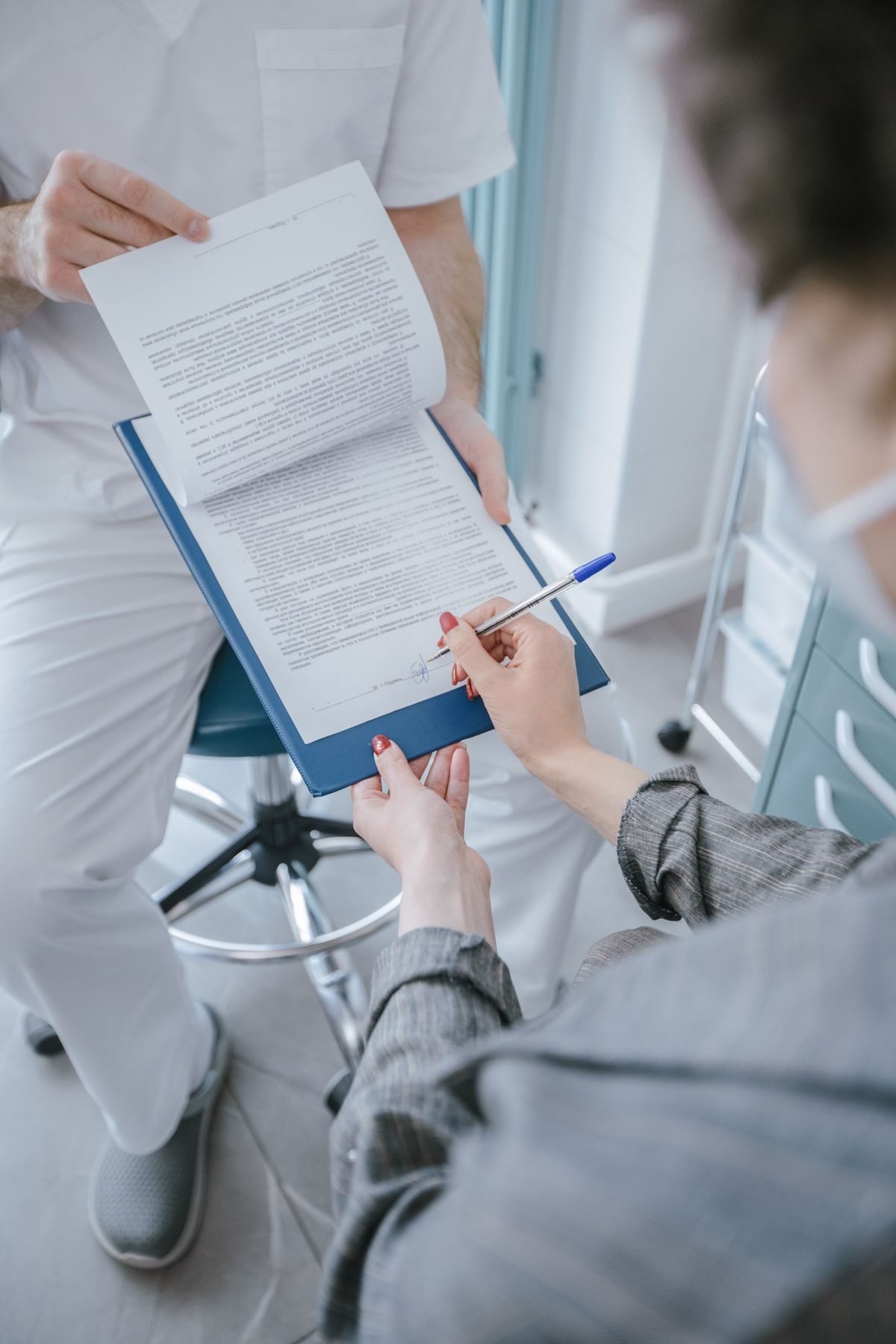 A patient reviewing and signing their new patient registration form