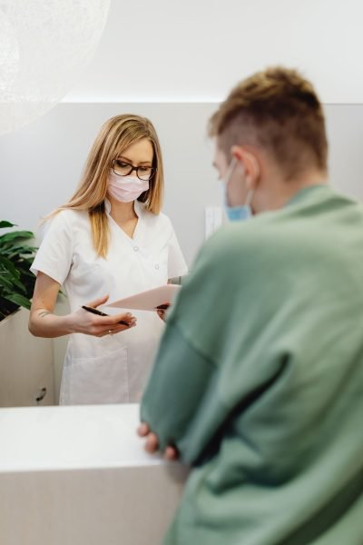 A receptionist assisting a patient checking in for an appointment