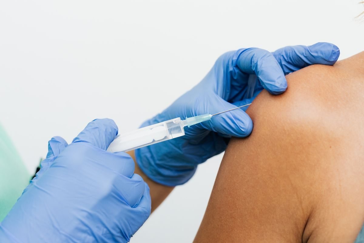 A nurse administering a flu vaccination injection